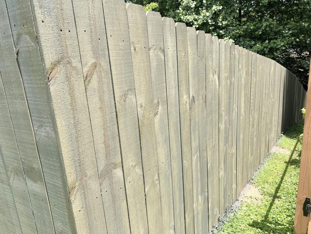 a wooden fence with trees in the background